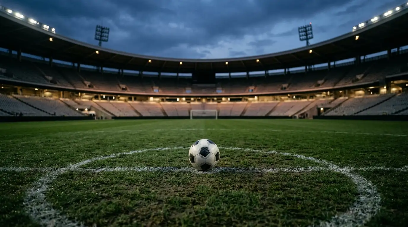Nogometna žoga na razdrapani travi sredi stadiona pred večerno tekmo svetovnega prvenstva